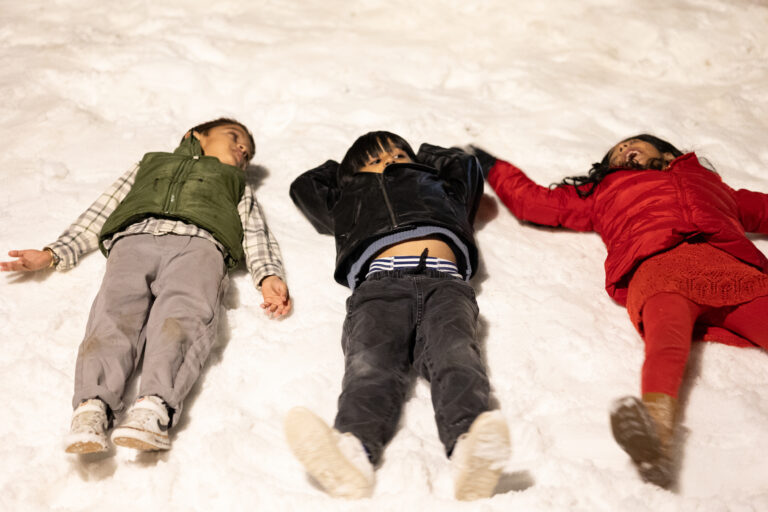 Kids making snow angels holiday 2025